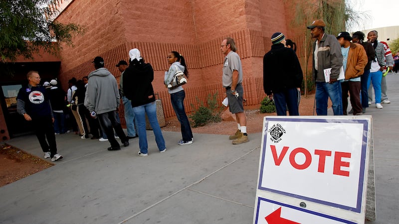 FILE - Voters stand in line to cast their ballots at the West Las Vegas Library, Tuesday, Nov....