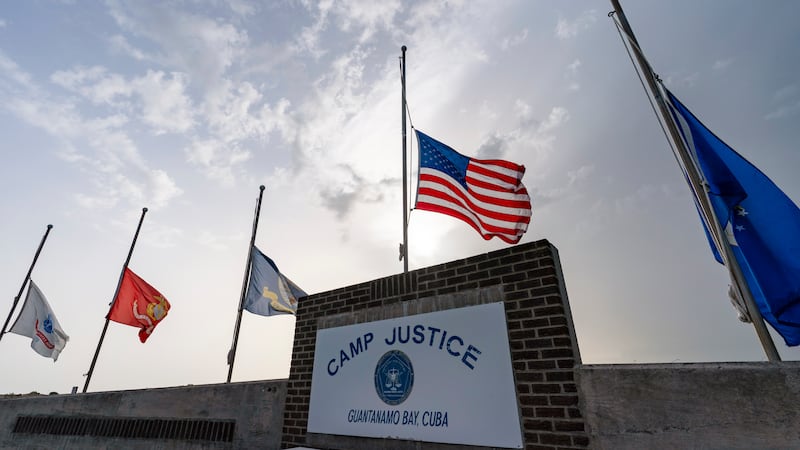 FILE - In this photo reviewed by U.S. military officials, flags fly at half-staff at Camp...