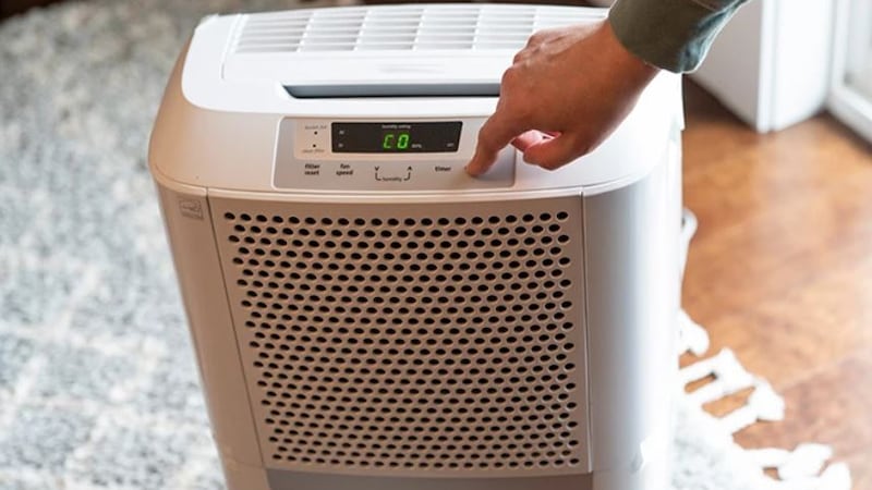 A photo of someone adjusting a de-humidifier.