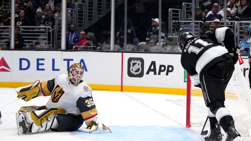 CORRECTS NAME AND TEAM OF GOALTENDER - Los Angeles Kings center Anze Kopitar, right, scores on...